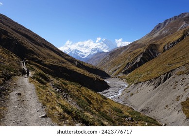 Hiking along a river on the Annapurna Circuit trek in Nepal