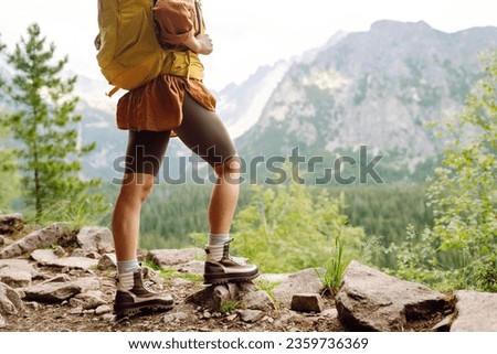 Hiking boot. Close-up of female legs in hiking boots on a hiking trail, on top of a mountain outdoors. Travel, vacation concept.