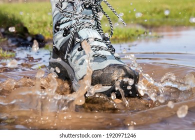 Hiking Boot Splashing In A Puddle Of Muddy Water