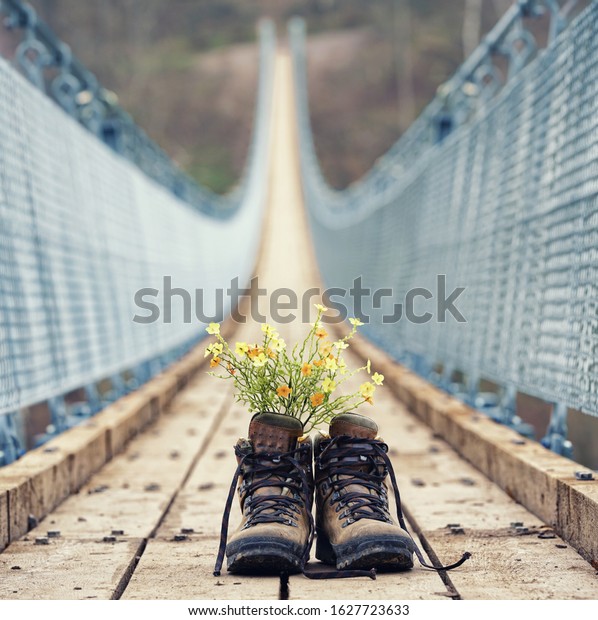 hiking\
boots with flowers on the hanging bridge in\
forest