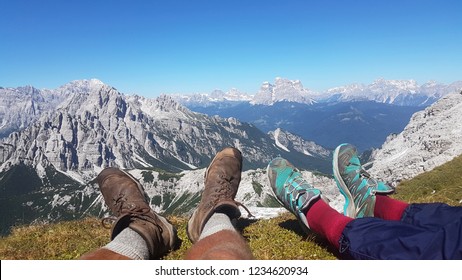 Hiking Boots Having Fun And Enjoying Wonderful Breathtaking Mountain View. Freedom Concept In Alps Mountain With Snow On Peak.