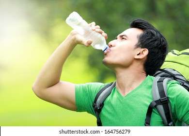 Hiking Concept. Thirsty Man Having A Break Drinking A Bottle Of Water