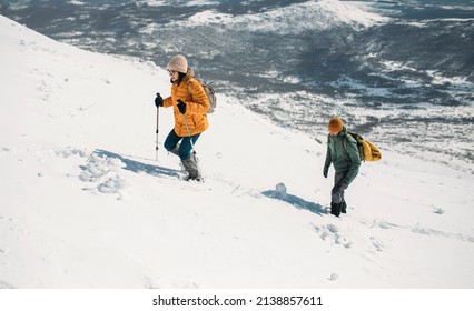 Hiking Couple In Gaiters Climbing Snowy Mountain