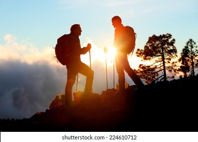 Hiking Couple Looking Enjoying Sunset View On Hike During Trek In Mountain Nature Landscape At Sunset. Active Healthy Couple Doing Outdoor Activities.