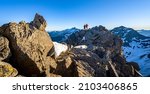 Hiking couple stands on the summit and looks towards Austria
