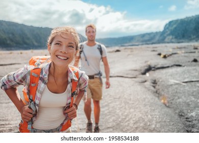 Hiking Couple Walking With Backpacks On Lava Field Trail In Hawaii. Summer Travel Happy Smiling Asian Girl And Man Hikers Outdoor Adventure On Big Island, USA.