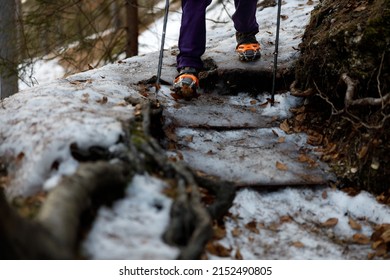 Hiking Downhill On Icy Mountain Trail With Winter Equipment