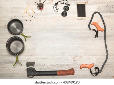 Hiking Equipment: Compass, Phone, Tent, Ax, Gas, Burner, Matches And Other Set On Wooden Background, Top View