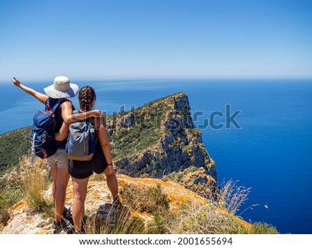 Hiking friends on a mountain top. Outdoor trekking in Mallorca island, adventure lifestyle. 