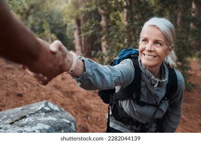 Hiking, helping hand and people in nature for climbing adventure, senior wellness and support for health. Happy woman or couple of friends hands reaching for teamwork on mountains or forest trekking - Powered by Shutterstock