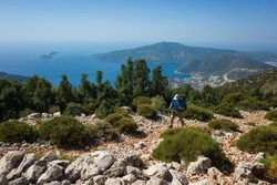 Hiking Lycian Way. Man Is Trekking On Stony Path High Above Mediterranean Sea Coast On Lycian Way Trail From Kalkan To Bezirgan, Outdoor Activity In Turkey