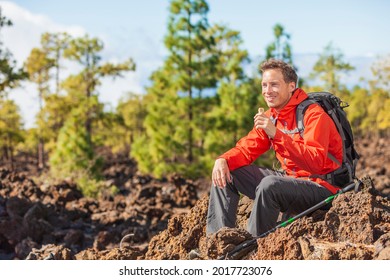 Hiking Man Eating Granola Protein Bar Snack During Mountain Hike Travel Camping Vacation In Nature Landscape. Happy Hiker Taking A Break With Healthy Food In His Backpack.