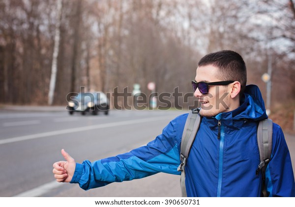 Hiking man hitchhiking the\
car