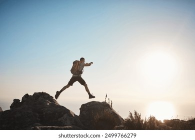 Hiking, man and jump on rocks for fitness, wellness and energy at sky mockup. Trekking, male athlete and confident on mountain with freedom, travel or adventure in nature space for muscle development - Powered by Shutterstock