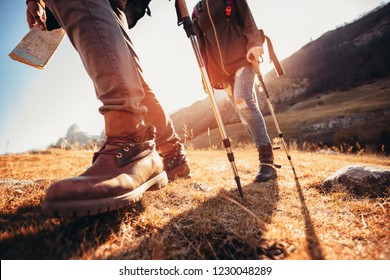 Hiking man and woman with trekking boots on the trail - Shutterstock ID 1230048289