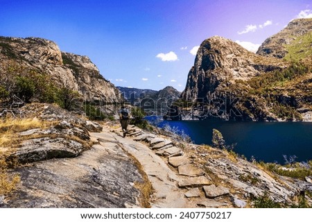 Hiking on the shoreline of Hetch Hetchy reservoir in Yosemite National Park, Sierra Nevada mountains, California; the reservoir is one of the main sources of drinking water for the San Francisco bay