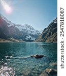 hiking on a snowy mountain in Fiordland Park New Zealand and lake