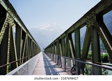 Hiking On The Swiss Alp Mountains. Metal Girder Bridge With Pathway.