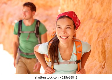 Hiking People - Couple Hikers In Bryce Canyon Walking Smiling Happy Together. Multiracial Couple, Young Asian Woman And Caucasian Man In Bryce Canyon National Park Landscape, Utah, United States.