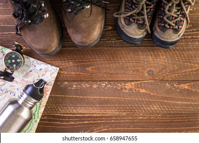 Hiking Shoes With Topo Map And Compass On A Wood Background.