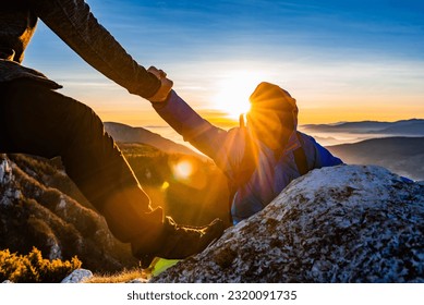 Hiking team people helping each other friend giving a helping hand while climbing up on the mountain rock adventure travel concept of support trust teamwork success. - Powered by Shutterstock