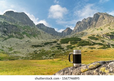 Hiking Thermomug Standing On A Rock On A Background Of Mountains