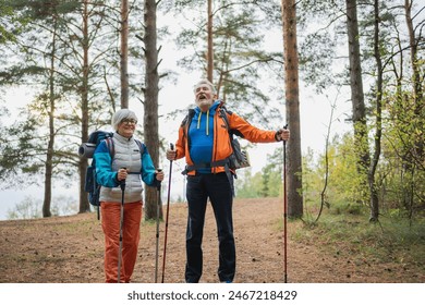 Hiking tourism adventure. Senior couple man woman enjoying outdoor recreation hiking in forest. Happy old people backpackers hikers enjoy walking hike trekking tourism active vacation beauty of nature - Powered by Shutterstock