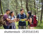 Hiking trail in the forest with friends. Walk through countryside and read the map. Hikers looking at map. Teamwork outdoor activity. Trekking. Camping and wild life concept.	