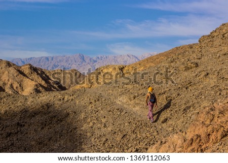 hiking travel backpacking woman walking on wilderness highland dry Middle East mountains nature environment  