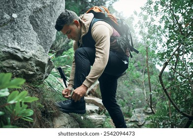 Hiking, travel and tying laces with man in nature for explore, health and adventure. Challenge, wellness and holiday with person and shoes trekking on path for walking, fitness and camping vacation - Powered by Shutterstock