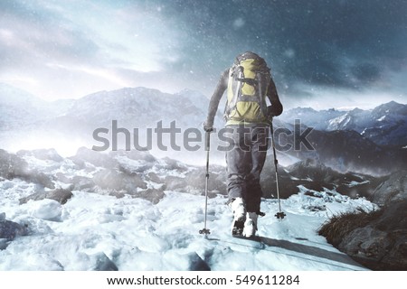 hiking in winter mountains at snowstorm