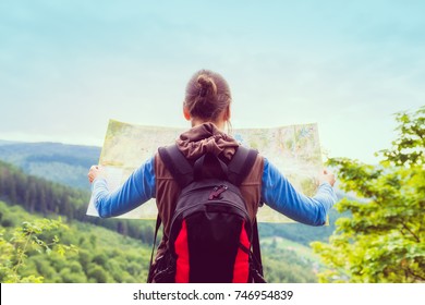 Hiking Woman Traveler With Backpack Checks Map To Find Directions In Wilderness Area, Real Explorer. Travel Concept