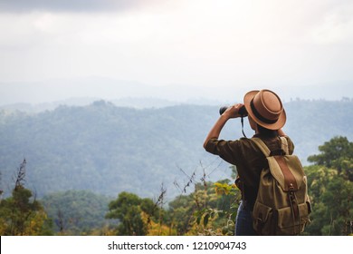 Hiking women use binoculars to travel and have a happy smile. - Powered by Shutterstock