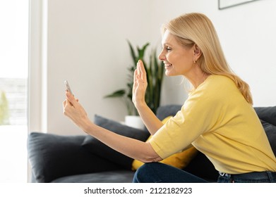 Hilarious Caucasian Woman Using Smartphone For Video Connection Staying At Home. Smiling Senior Lady Waving Hello, Greeting Friend Or Family, Using Mobile App For Video Calling