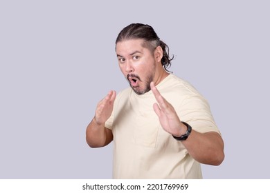 Hilarious And Funny Scene Of A Stocky Man Threatening To Use Kung Fu To Defend Himself. Probably Pretending Or Acting For Fun. Isolated On A Gray Background.