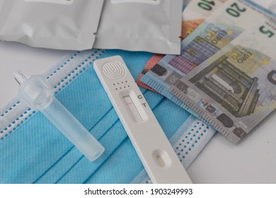 Hildesheim, Germany - January 27, 2021: Close-up Of A Corona Spit Test At Home Where You Have The Results After 20 Minutes With Toy Money In The Background