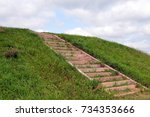 Hill with green grass and wood stairs