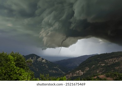 Hill landscape with storm clouds, forming tornado, dramatic weather scene, dark skies over rolling hill - Powered by Shutterstock