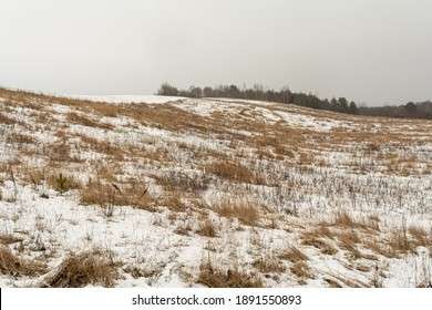 Hills with dry grass are covered with snow. Gloomy winter day. Nature landscape background - Powered by Shutterstock