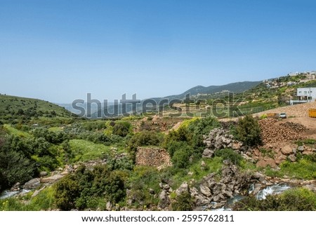 The hills of the Golan Heights during spring with green grass, water streams and sunny skies.