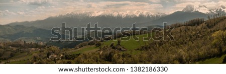 Hills, towns, forests, and a gorgeous mountain in background with its peak in the couds. High density 50 megapixel panoramic view of Gran sasso of Italy
