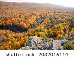 Hills and valley in Michigan with trees in brilliant fall color above a small river