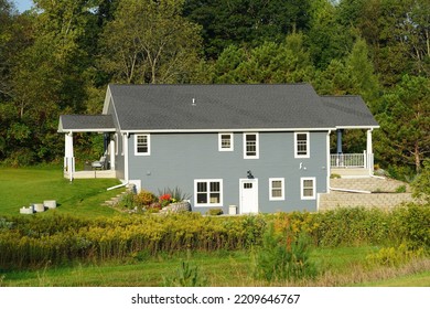 Hillsboro, Wisconsin USA - September 20th, 2022: Large Grey Family Home Sits On Hillside Near A Forest.