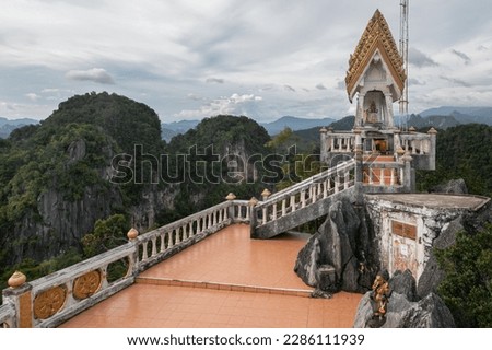 Hilltop Pagoda at the Tiger Cave Temple (aka Wat Tham Suea) viewpoint in Krabi. Around are jungle hills, pointed cliffs, endless tropical valley in the distance.