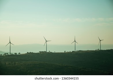 Hilly landscape covered by trees and several wind turbines for electric power generation, on sunset at Guarda. This friendly and well-kept medieval town is the highest in the continental Portugal.