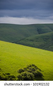 Hilly landscape of grass with dramatic clouds