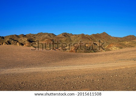 Hilly landscape in summer. Country road. Hills in the steppe. Blue sky. There is no one