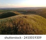 Hilly local outside the city, rural landscape, evening time after sunset, grassy mountainside. High quality photo