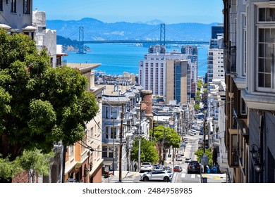 A Hilly street in San Francisco with the Oakland Bay Bridge  - Powered by Shutterstock