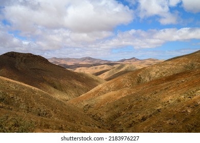 Hilly Terrain Against Cloudy Sky